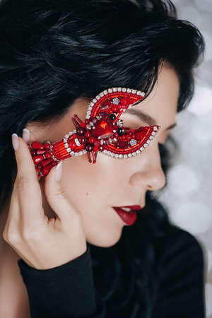 Portrait of beautiful young woman holding a handmade cancer brooch. Fashion photoの写真素材