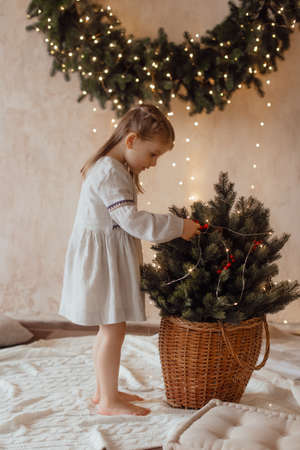 Photo of a little beautiful girl in a Christmas wreathの写真素材