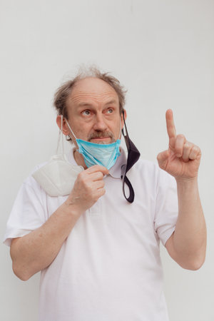 Stock Photo - Senior man in a white t-shirt wearing medical mask