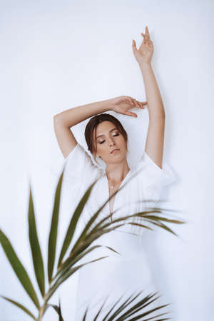 Beautiful sophisticated bride in a wedding dress in a bright roomの写真素材