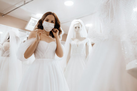 Female bride in protective mask. Protection against virus infection, quarantine and online marriage concept.の写真素材