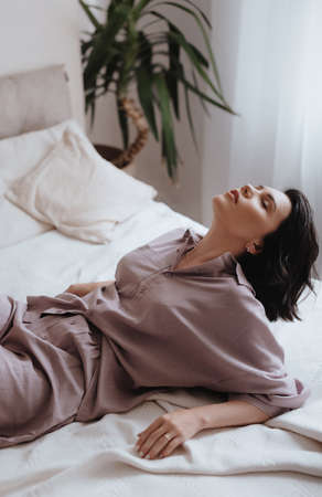 Gorgeous beautiful girl is in elegant pajamas is in bed. Natural female beauty.の写真素材