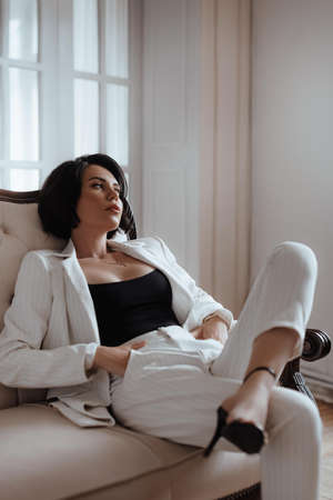 Gorgeous woman in elegant white suit. Natural colors. Natural female beauty.の写真素材