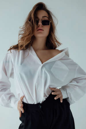 Ukrainian  young  girl  in a white shirt  on light background. Female body and style concept....