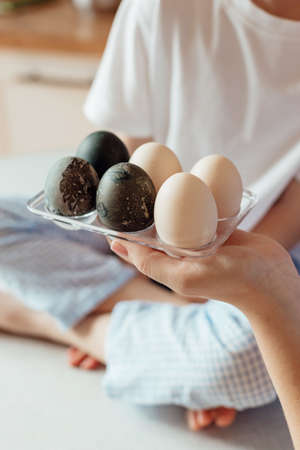 Happy family preparing Easter eggs indoors. Mother and boy celebrating happy Easter holiday together...