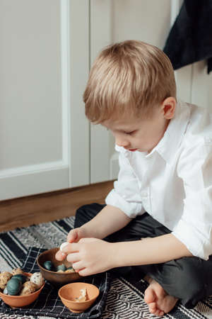 Happy family preparing Easter eggs indoors. Mother and boy celebrating happy Easter holiday together...
