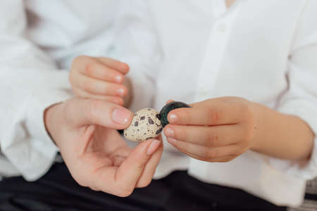 Happy family preparing Easter eggs indoors. Mother and boy celebrating happy Easter holiday together at home.の写真素材