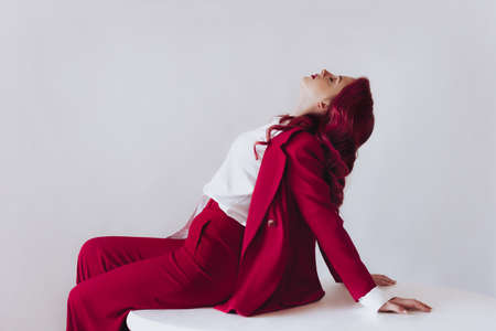 Ukrainian young girl in a red suit on light background. Female body and style concept. Advertisement...