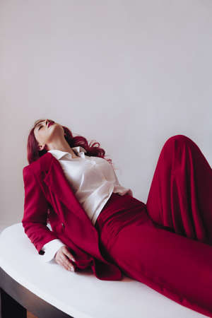 Ukrainian young girl in a red suit on light background. Female body and style concept. Advertisement or clothing sale design.の写真素材