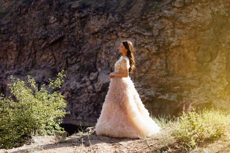 Fashionable young model in boho style dress on a background of rocks. Female beauty and style concept.の写真素材