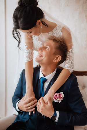 Beautiful young couple, the bride and groom. Luxurious light interior. Wedding day conceptの写真素材