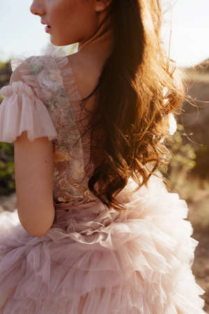 Fashionable young model in boho style dress on a background of rocks. Female beauty and style concept. Advertisement or clothes sale design.の写真素材