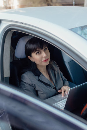 Shot of a happy middle aged woman sitting in a car. Confident businesswoman in casual clothes with...