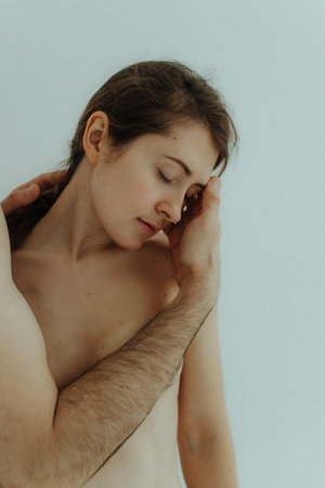 Cheerful woman and man standing on white background, isolated. Concept of natural beauty and feeling comfortable. Body positive young couple.の写真素材