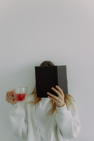 Smart younggirl with a notepad in her hands and a glass of juice, on a white background with space...