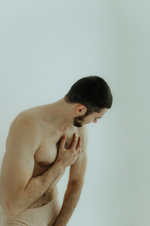 People, healthcare and problem concept - man suffering from back pain or reins. Close up hands touching back pain. Man standing on white background. No focus blurred and noise effect.の写真素材