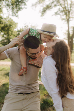 Summer sunny day for a young family, dad, mom and little son became joyful and happy. Happy family concept photo. No focus blurred and noise effectの写真素材