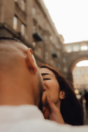Kiss close-up. Love story. Walk around the city. A woman in a white suit. Guy in a t-shirt. Love and hugs. No focus blurred and noise effect. Vintage photographyの写真素材