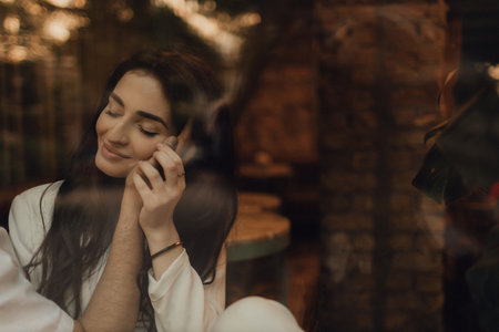 Kiss close-up. Love story. Behind the cafe window. A woman in a white suit. Guy in a t-shirt. Love and hugs. No focus blurred and noise effect.の写真素材