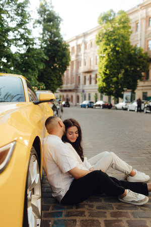 The concept of buying a new car. Beautiful couple in their new yellow car on the city street. No focus blurred and noise effect.の写真素材