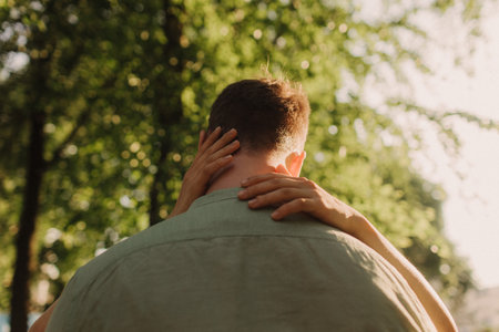 Beautiful couple hugging and walking in park. Happy family concept photo. A woman and a man in basic clothes on the background of the city and the park. No focus blurred and noise effectの写真素材