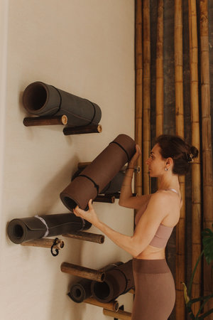 Sporty young woman doing yoga practice on yoga mat is in the yoga room. Vintage tonned. Concept of...