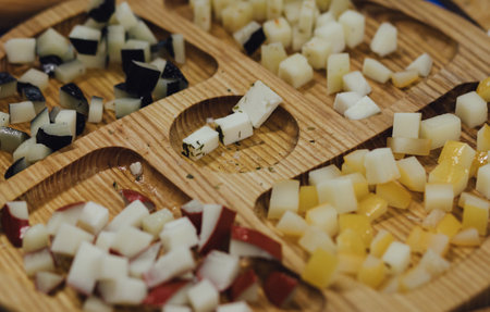 hand made baked stuffed rolls and pieces of cheese. Delicious pastries on wooden cutting board and parchment paper at the street food fair. Soft focus blurred and noise effect.の写真素材
