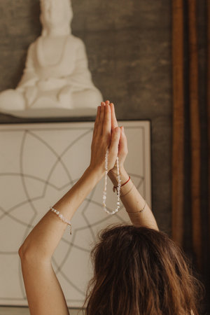 Woman holds jewelry made of natural stones in her hand, her hands are decorated with rings and...