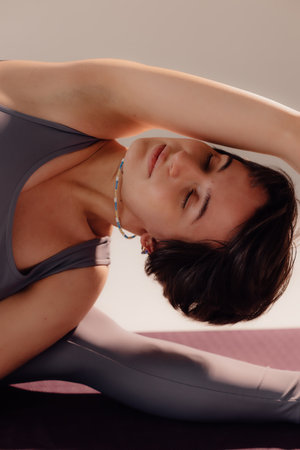 Sporty young woman doing yoga practice on white background. Concept of healthy life and natural...