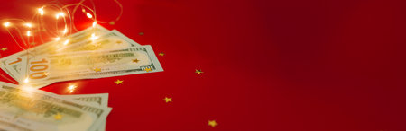 Banner for holiday card with money US dollars. Background of one hundred dollar bills. Banknotes, paper currency on red background. Concept of american and global economy, exchange rate, xmas.の写真素材