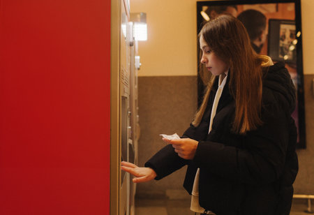 Tourist teenage girl at train station using smartphone map, social media check-in, or buy ticket booking. Modern travel app technology, lone traveler, Winter vacation railroad adventure concept.の写真素材