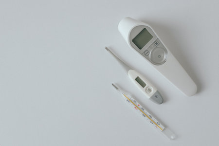 Comparison of mercury thermometer, infrared and electronic thermometer baby thermometer for measuring human body temperature on light background. Types of thermometers. Copy spaceの写真素材