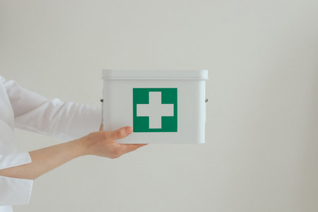 Medicine, healthcare and people concept - Close up doctor in white uniform is holding a first aid...