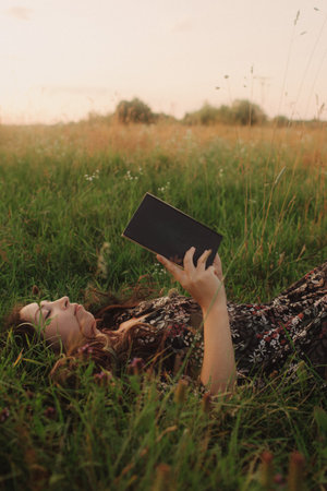 Calm woman with book enjoying the moment and slow life in nature. Concept of green tourism, slow...