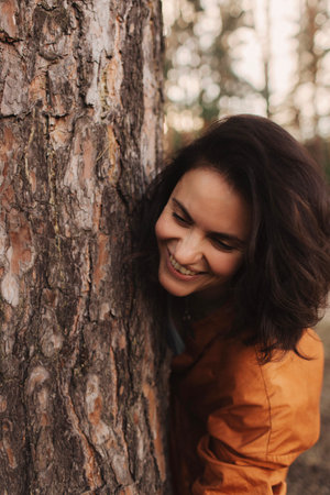 Happy adult lady hug tree trunk in outdoor leisure park activity. Concept of environment and ambient nature care. People love planet earth and stop deforestation lifestyleの写真素材