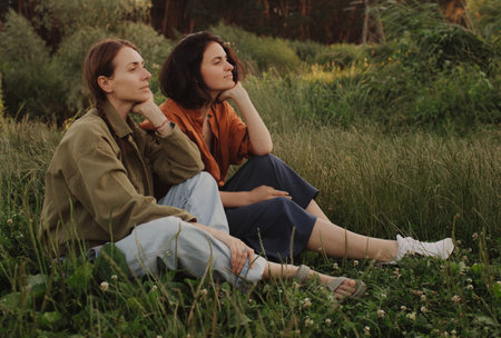 Two happy young Caucasian women enjoying vacation in the forest. Cheerful beautiful girls of...