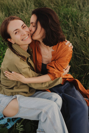 Two happy young Caucasian women enjoying vacation in the forest. Cheerful beautiful girls of generation z pose for photo with mobile phone. Strong female friendship. Part of the series.の写真素材