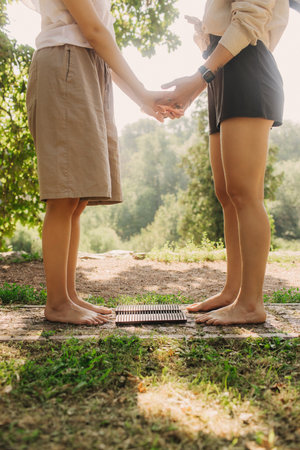 Close-up Caucasian woman stands on sadhu boards with therapist support. Practice yoga, meditation, concentration. Yoga meditation exercise. Part of a series.の写真素材