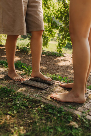 Close-up Caucasian woman stands on sadhu boards with therapist support. Practice yoga, meditation, concentration. Yoga meditation exercise. Part of a series.の写真素材