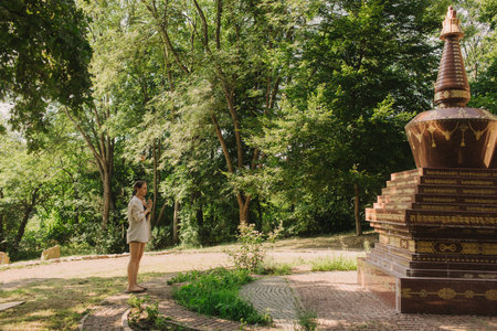 Caucasian woman stands on sadhu boards in park. Practice yoga, meditation, concentration. Feet on sharp nails sadhu board. Yoga meditation exercise. Part of a series.の写真素材