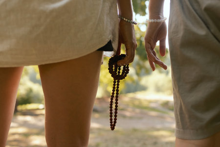 Close-up female hands with beads for meditation. Mentor and student conduct spiritual practice. Mindful meditation concept. Wellbeing. No focus blurred and noise effect. Part of the series.の写真素材