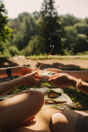 Close up of female mentor and student before Mindful meditation and yoga in an open area. Deep relaxation and inner contemplation of people. Facilitating meditative experience. Part of the series.の写真素材