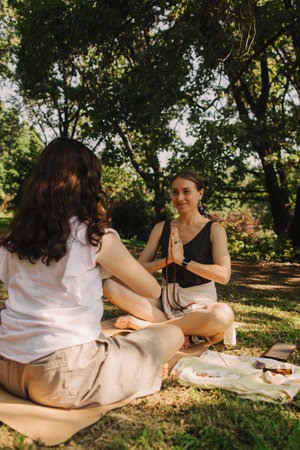 Mentor and student before Mindful meditation and yoga in an open area. Deep relaxation and inner contemplation of people. Facilitating meditative experience. Part of the series.の写真素材