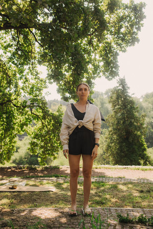 Caucasian woman stands on sadhu boards in park. Practice yoga, meditation, concentration. Feet on sharp nails sadhu board. Yoga meditation exercise. Part of a series.の写真素材