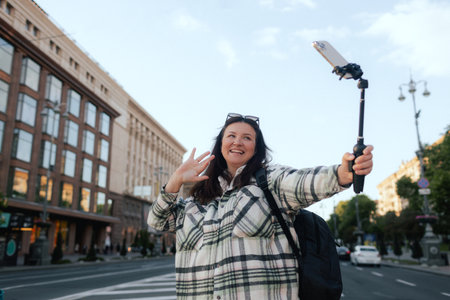 Vlogger traveler woman recording video on phone camera on Khreshchatyk in Kyiv, Ukraine. Gen Z Plus...