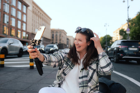 Vlogger traveler woman recording video on phone camera on Khreshchatyk in Kyiv, Ukraine. Gen Z Plus...