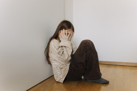 Photo of Expression of lonely female teenager sitting on the floor at home. Pensive teen. Depression, teen depression, pain, suffering, mental health.の写真素材