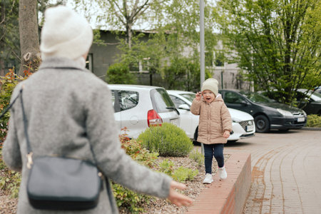 Mother with her daughter outdoors, close-up. A woman and a child are walking in the park in the cold season. The concept of solo parenting and raising children. Part of a seriesの写真素材