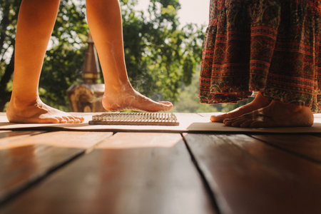 Close-up Caucasian woman stands on sadhu boards with therapist support. Practice yoga, meditation, concentration. Yoga meditation exercise. Part of a series.の写真素材
