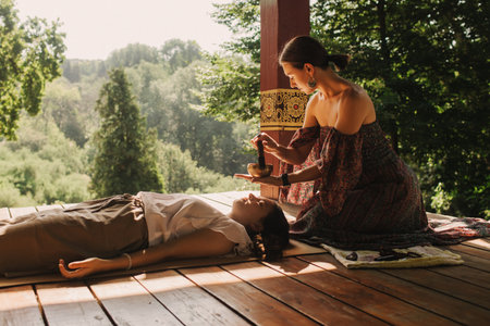 Close up of female mentor and student before Mindful meditation and yoga in the gazebo. Facilitating meditative experience. Part of the series. Tibetan singing bowl. Soft focus, blurred, noise effectの写真素材